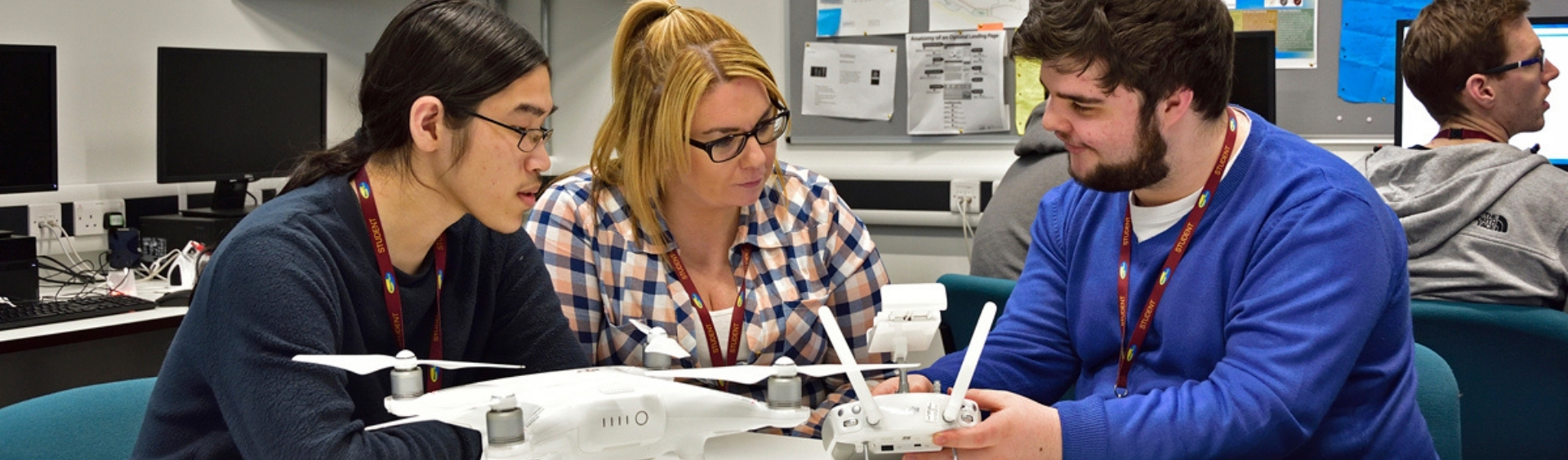 Three WMC Beginners/Intermediate Excel students playing with drone in Computing classroom